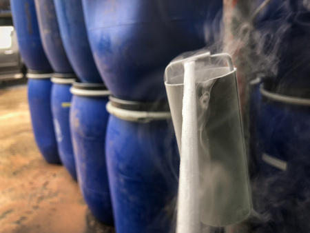 Close up of container with liquid nitrogen,Cold metal pipe smoking from transferring liquid nitrogenの写真素材