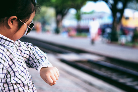 Cute girl in train station waiting to travel. Summer holiday and travel concept.の写真素材
