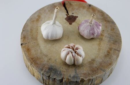 Fresh garlic, placed on a wooden chopping board.の写真素材
