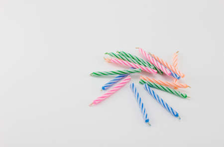 Multicolored birthday candles placed on a white background.