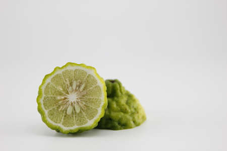 Bergamot cut in half on white background.