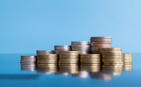 Stacks of coins on blue background, business and finance concept.の写真素材