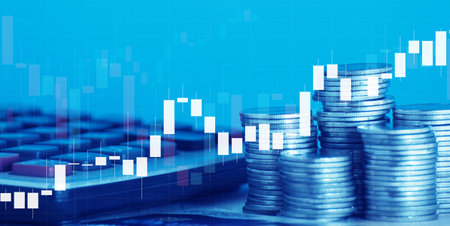 Double exposure of coin stack with calculator and financial graph on blue backgroundの写真素材