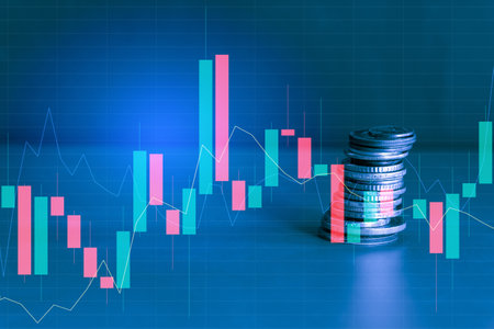 Stack of coins with candlestick chart on blue background. Financial concept.の写真素材