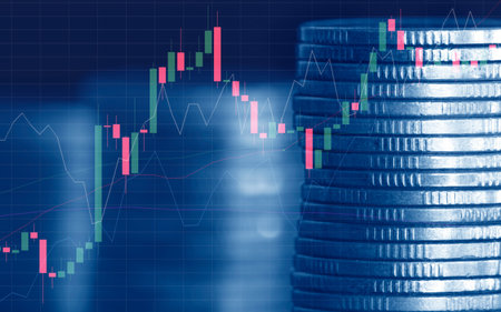 Stacks of coins with candlestick chart on blue background.の写真素材