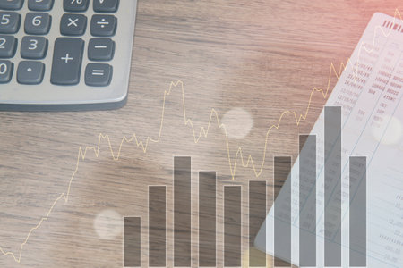 calculator and graph on wooden table background, business and finance conceptの写真素材