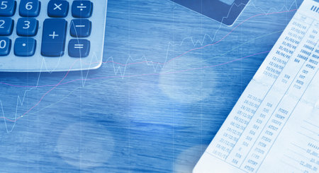calculator and calculator on the table with stock market graph backgroundの写真素材
