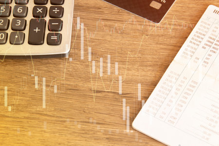 calculator and calculator on the wooden table with stock market graphの写真素材