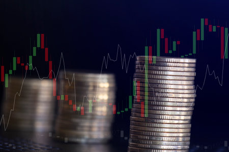 Stacks of coins with stock market or forex trading graph and candlestick chart suitable for financial investment concept.の写真素材