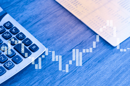 calculator and financial chart on wooden table, business and finance conceptの写真素材