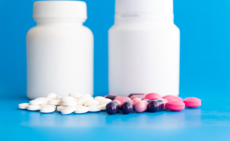 pills on blue background with copy space. Focus on foreground, shallow DOF.