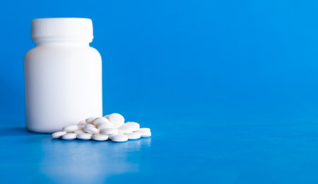 White pills on blue background. Focus on foreground, shallow DOF.の写真素材