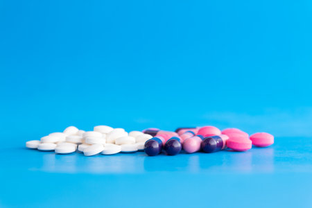 Colorful pills on blue background. Focus on foreground, shallow DOF.の写真素材