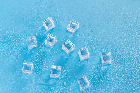 Ice cubes with water drops on a blue background. Top view.の写真素材