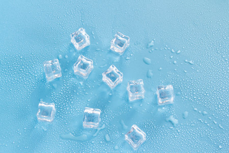 Ice cubes on a blue background with water drops. Top view.の写真素材