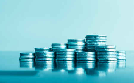 Stacks of coins on table with blue background, business and finance concept idea.の写真素材