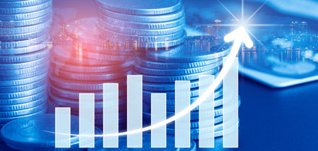 Double exposure of coin stack with finance graph and cityscape background.の写真素材