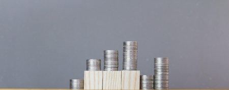 Stacks of coins on wooden table, business and finance concept.