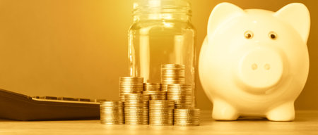Piggy bank and coins on the table. Savings concept.の写真素材