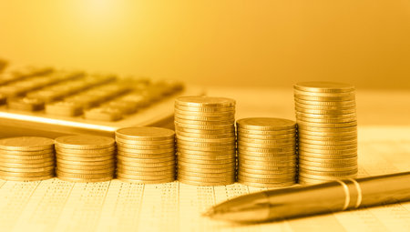 Stacks of coins with calculator and pen, business and financial conceptの写真素材