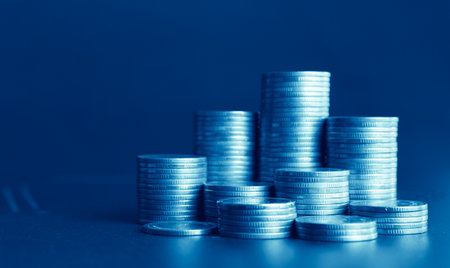 Coins stacked on each other in different positions. The background is blue.の写真素材
