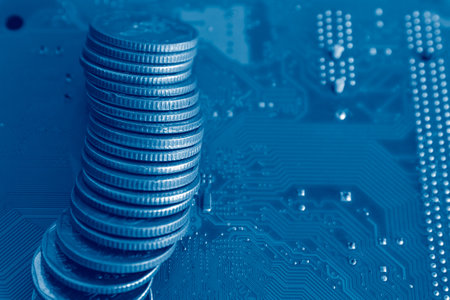 Close up of coin stack on computer circuit board. Blue color.
