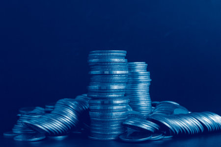 Coins stacked on each other in different positions, with blue background.の写真素材