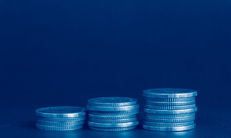 Coins stacked on each other in different positions on a dark blue backgroundの写真素材