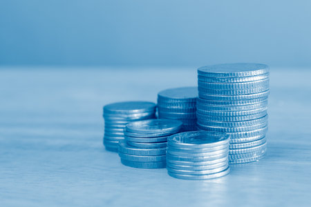 Coins stacked on each other in different positions with blue tone.の写真素材