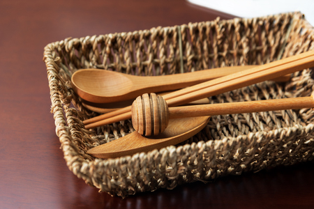 wooden spoon kitchen utensils in basket on the tableの写真素材