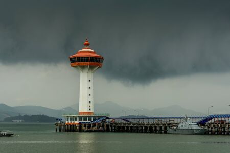 ranong pier light house and cumulonimbus in rainny seasonの写真素材