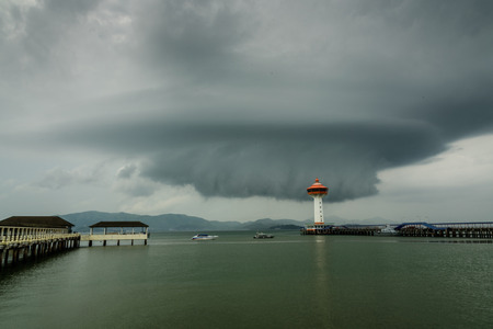 ranong pier light house and cumulonimbus in rainny seasonの写真素材