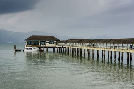 ranong pier light house and cumulonimbus in rainny seasonの写真素材