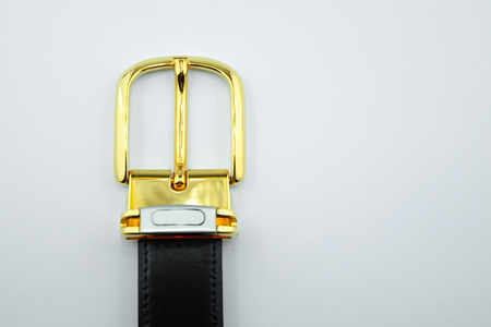 Gold buckle black leather strap on a white background.の写真素材