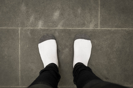young girl with black pants and white sock standing on cement floorの写真素材