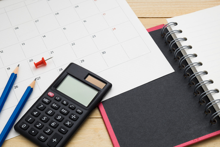 top view empty notebook ,calculator,pencil,pin and calendar put on wooden floor for to do sometingの写真素材