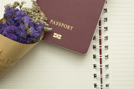 bouquet flower and passport put on empty notebook paper backgroundの写真素材