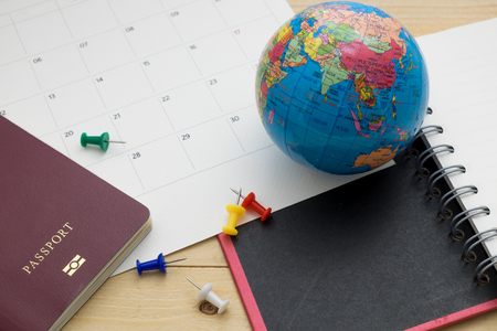 top view passport and accessory prepare for planning holiday on wooden floor backgroundの写真素材