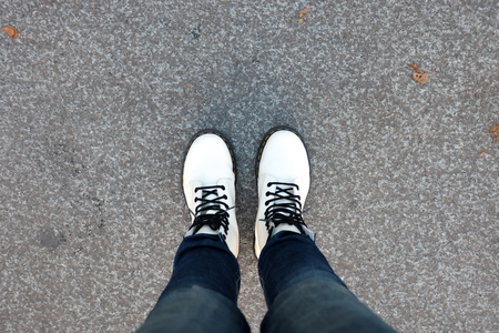 foot of woman with blue jean pants standing in cement floor backgroundの写真素材