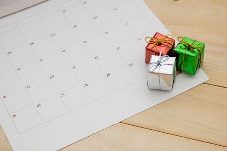 three small gift box put on calendar page have wooden backgroundの写真素材