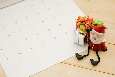 three small gift box and small satan claus put on wooden backgroundの写真素材