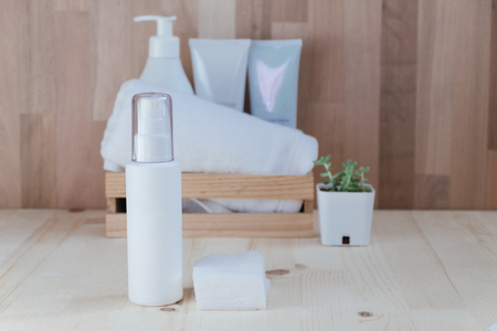 skin care collection contain spray bottle and cotton placed on wood floor. have wood basket include cream and towel with wooden wall are background. image for cosmetic, make up, women, beauty conceptの写真素材