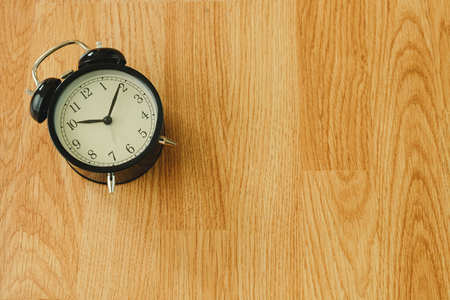 top view. retro alarm clock placed on wooden table are background. this image for object, equipment, accessory conceptの写真素材
