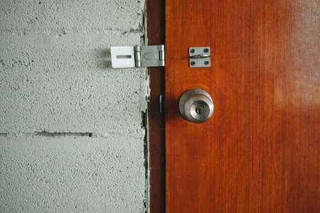 old cement walls and wooden doors are not locked. this image for interior, building, texture, abstract, background conceptの写真素材