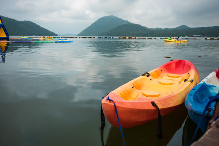 two colorful canoe boats float on water of lake has sky, mountain are background. image for vehicle, sports, nature, scenery, transport conceptの写真素材