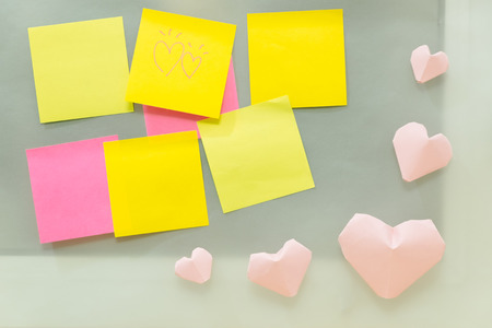 valentine day background blank post note paper sticky on glass with pink heart. image of business, present, idea, love, celebration, nobody, copy space, decoration conceptの写真素材