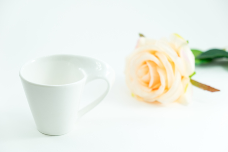isolated background white coffee cup and rose place on white table with copy space. image for food, flower, valentine, appliance, decoration, plant, cafe conceptの写真素材