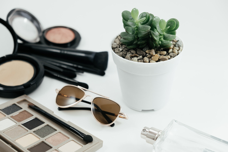 isolated cosmetic object, powder, glasses, perfume bottle and beautiful cactus on white background with copy space. image for plant, flower, beauty, product, valentine, brush, makup conceptの写真素材