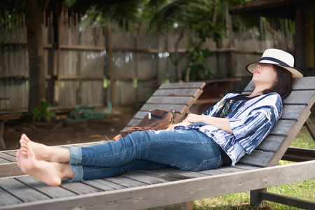 summer beach vacation young woman with hat relaxing chair have nature backgroundの写真素材