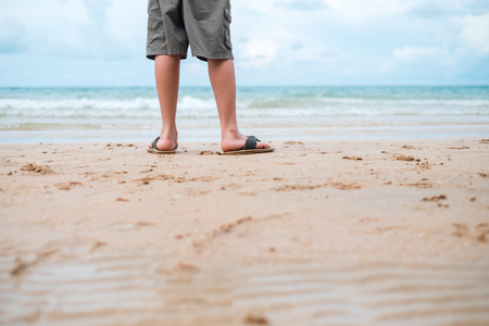 nature background close up leg of men standing alone on beach with copy space. image for summer, person, scenery, body, tropical conceptの写真素材